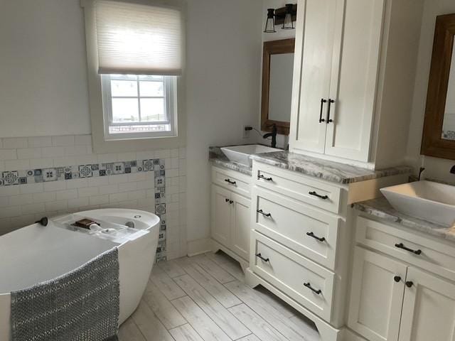 200 Marlin Rd, White House, TN 37188 - bathroom with a freestanding tub, two vanities, wood finished floors, and a sink