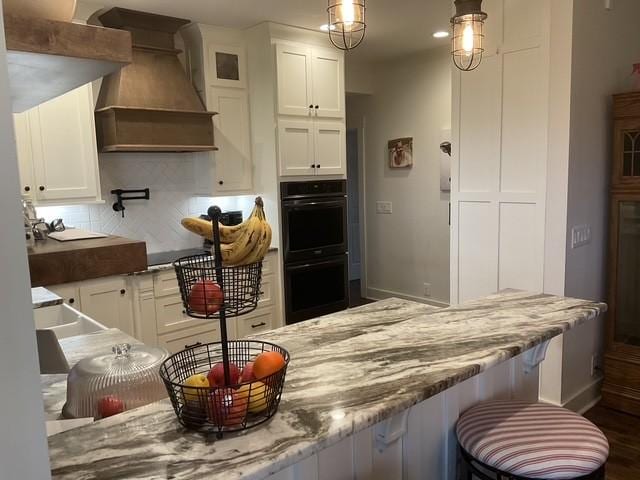 200 Marlin Rd, White House, TN 37188 - kitchen featuring tasteful backsplash, dobule oven black, white cabinetry, and custom range hood