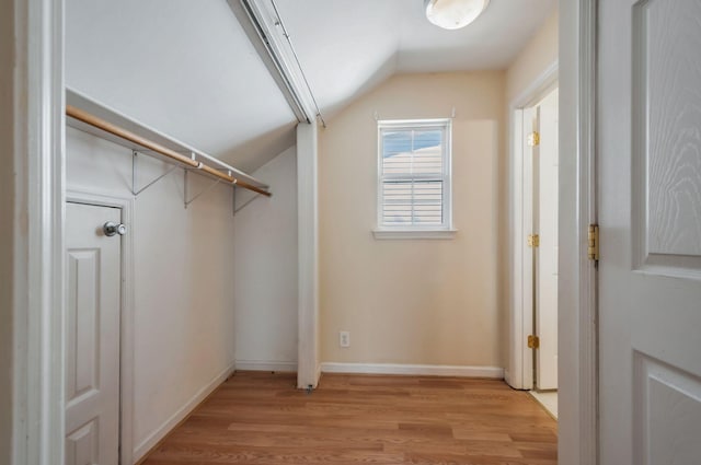 spacious closet featuring light wood finished floors and lofted ceiling