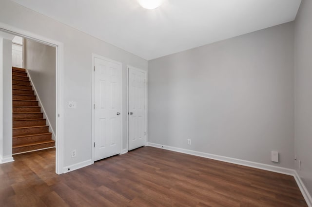 unfurnished bedroom featuring dark wood-style floors and baseboards