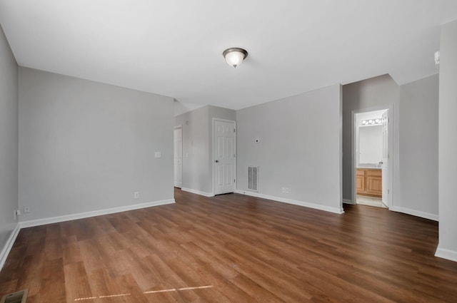 spare room featuring visible vents, baseboards, and wood finished floors