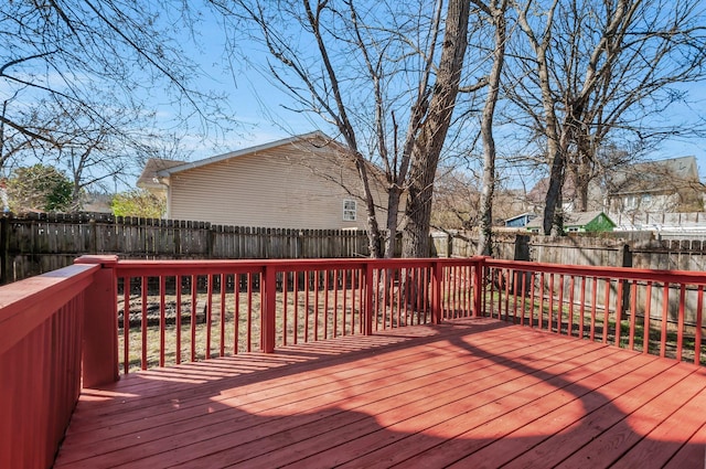 wooden deck with a fenced backyard