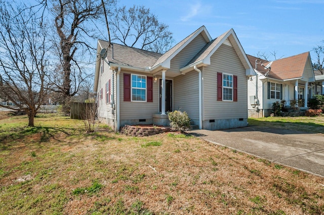 view of front of house featuring crawl space, driveway, a front lawn, and fence