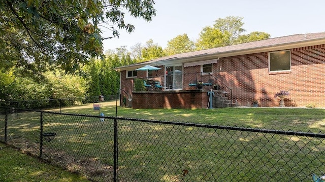 back of house with a yard, a fenced backyard, and brick siding