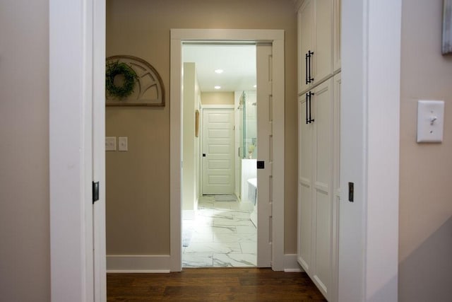 corridor featuring baseboards and marble finish floor