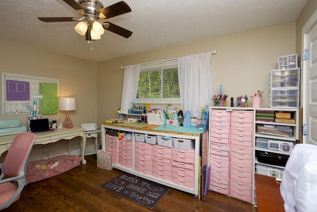 home office with a ceiling fan, wood finished floors, and a textured ceiling