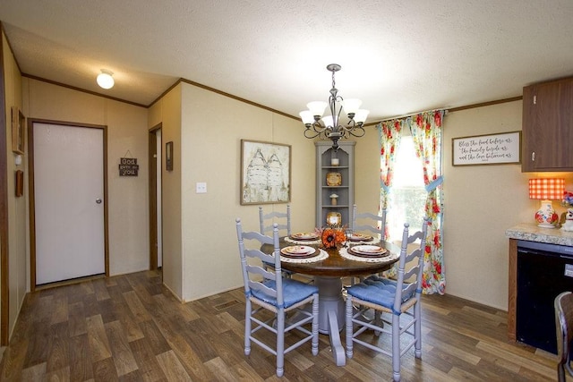 dining room featuring dark wood finished floors, an inviting chandelier, ornamental molding, and a textured ceiling