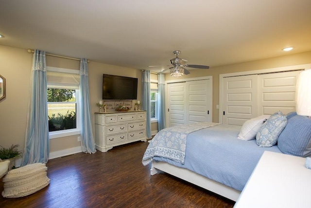 bedroom featuring baseboards, recessed lighting, dark wood-style flooring, ceiling fan, and two closets