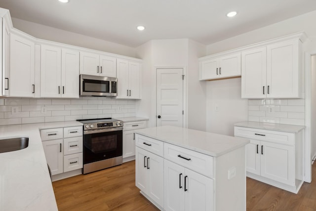 kitchen featuring recessed lighting, appliances with stainless steel finishes, white cabinetry, and light wood-style floors