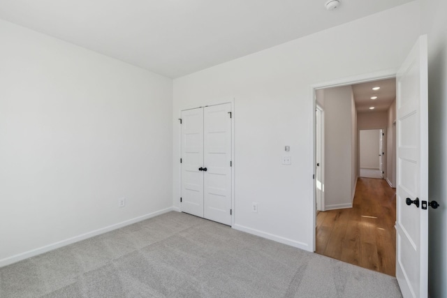 unfurnished bedroom with a closet, carpet flooring, and baseboards