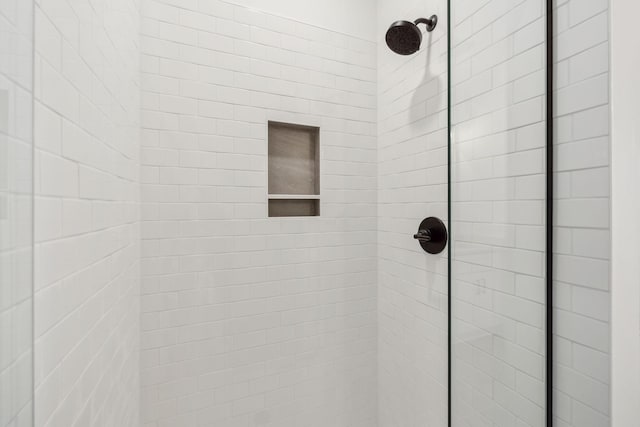 interior details featuring a tile shower