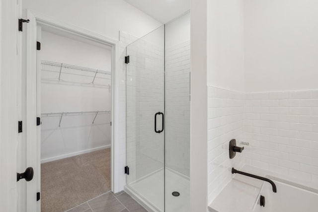 bathroom with a walk in closet and a stall shower