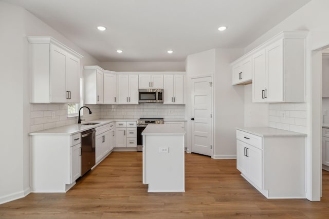 kitchen featuring a sink, white cabinets, light wood-style floors, and stainless steel appliances