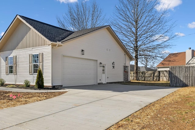 view of side of property with fence, a shingled roof, concrete driveway, a garage, and board and batten siding