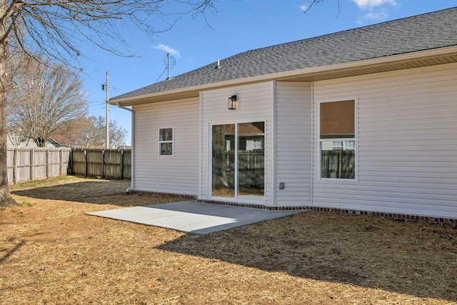back of house featuring a patio area, fence, and roof with shingles