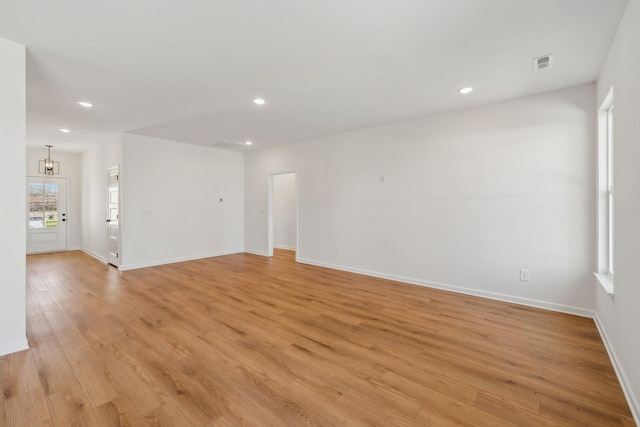 empty room with light wood-type flooring, visible vents, baseboards, and recessed lighting