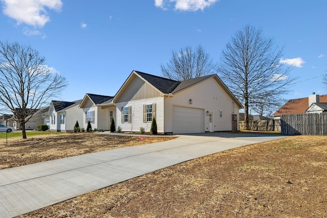 ranch-style home with fence, driveway, an attached garage, board and batten siding, and a residential view
