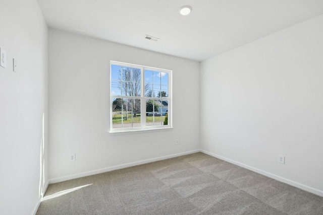empty room featuring visible vents, baseboards, and carpet