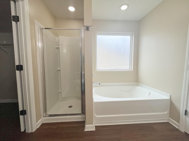 full bath featuring a bath, recessed lighting, a shower stall, and wood finished floors