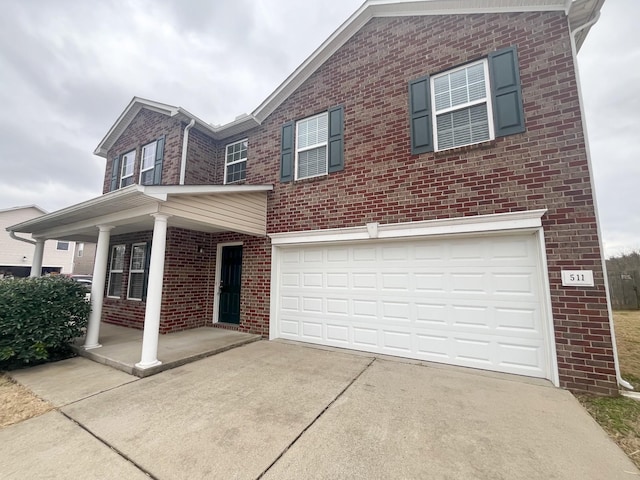 view of front of home with brick siding, an attached garage, covered porch, and driveway