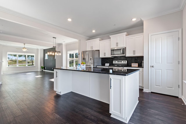 kitchen featuring white cabinetry, dark countertops, a sink, and stainless steel appliances