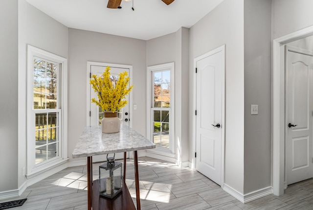 interior space with visible vents, baseboards, wood tiled floor, and a ceiling fan