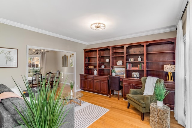 office space featuring a notable chandelier, light wood-style floors, and crown molding