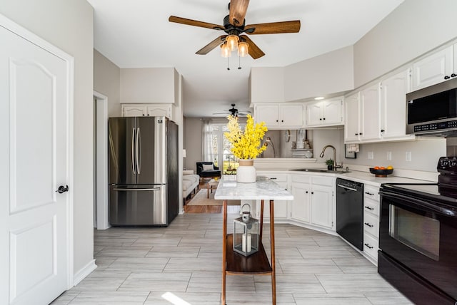 kitchen featuring a sink, black appliances, light countertops, and white cabinetry