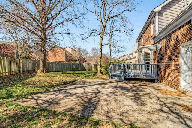 view of yard with a wooden deck and a fenced backyard