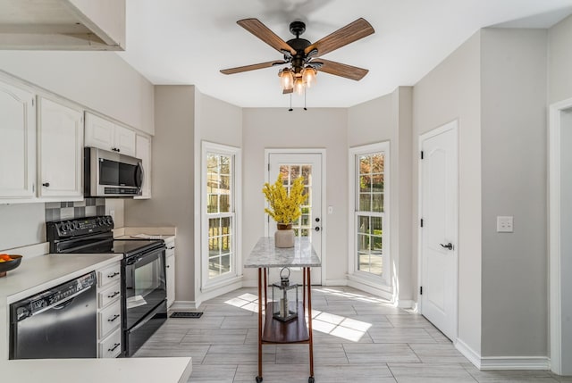 kitchen with black appliances, a ceiling fan, white cabinets, light countertops, and baseboards