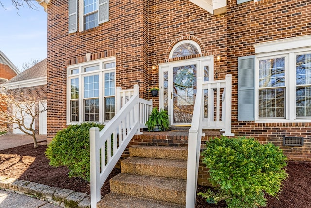 entrance to property with brick siding and roof with shingles