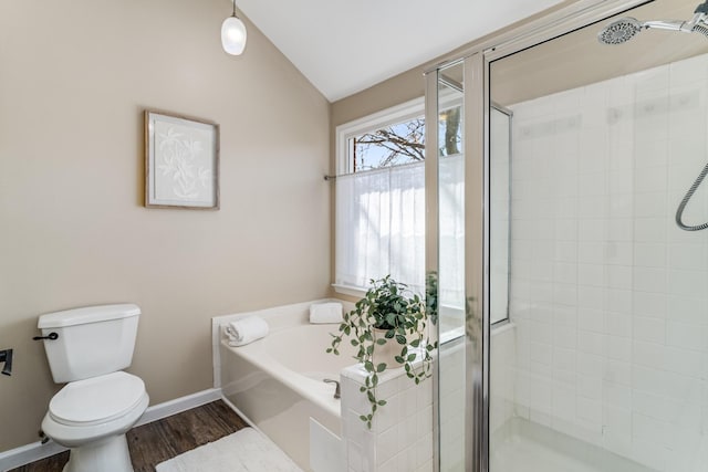 bathroom featuring baseboards, toilet, lofted ceiling, a stall shower, and a bath