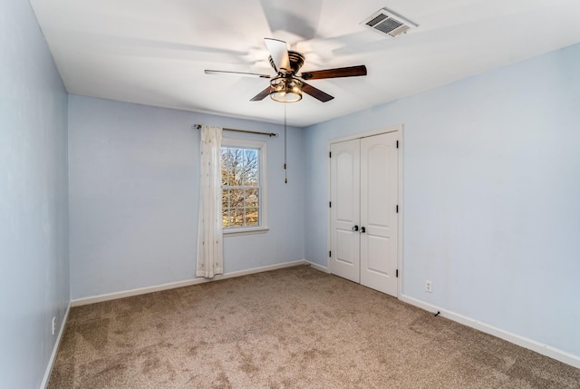 spare room featuring visible vents, carpet flooring, a ceiling fan, and baseboards