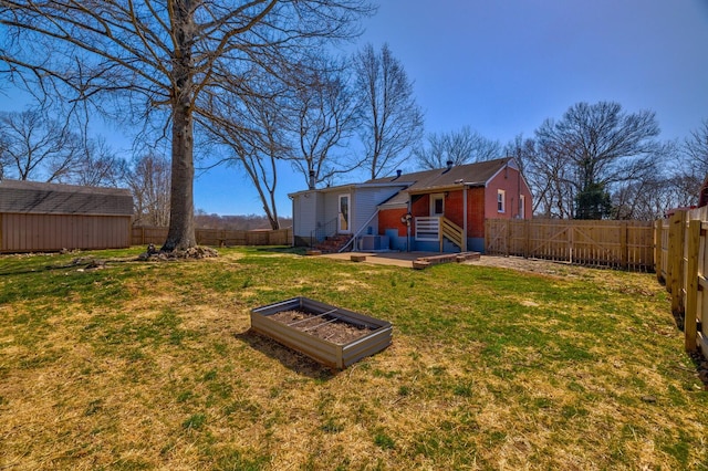 view of yard with entry steps, an outdoor structure, and a fenced backyard