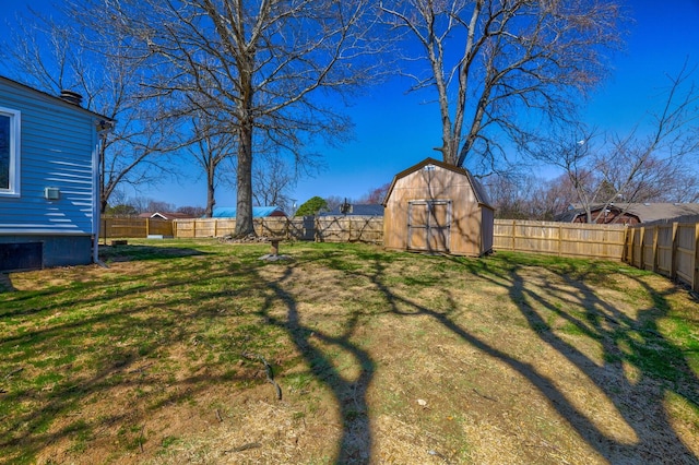 view of yard with an outbuilding, a fenced backyard, and a shed