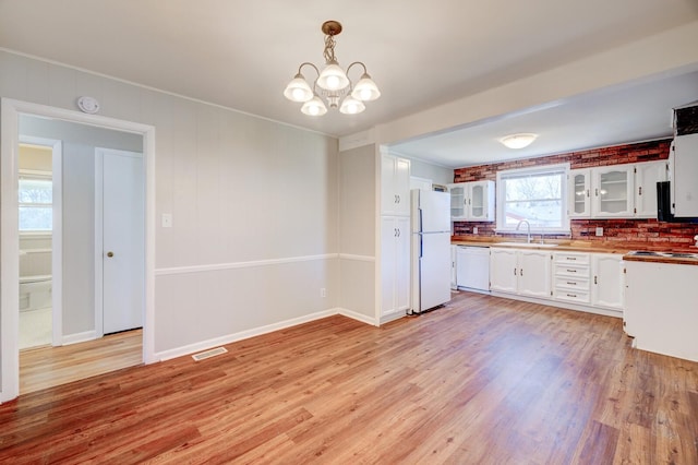 kitchen with visible vents, white appliances, white cabinets, light wood finished floors, and glass insert cabinets