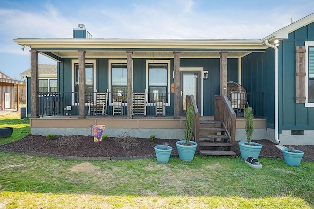 view of front of house featuring crawl space, covered porch, board and batten siding, and a front lawn