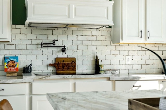 kitchen featuring custom range hood, backsplash, and white cabinets