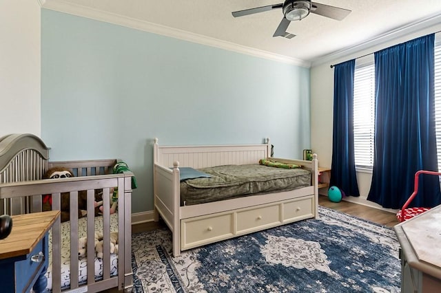 bedroom with visible vents, wood finished floors, crown molding, baseboards, and ceiling fan