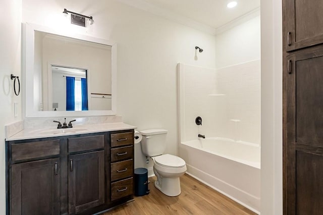 full bathroom with toilet, wood finished floors,  shower combination, crown molding, and vanity