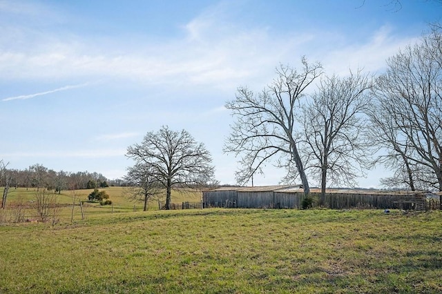 view of yard featuring an outbuilding, an outdoor structure, and a rural view