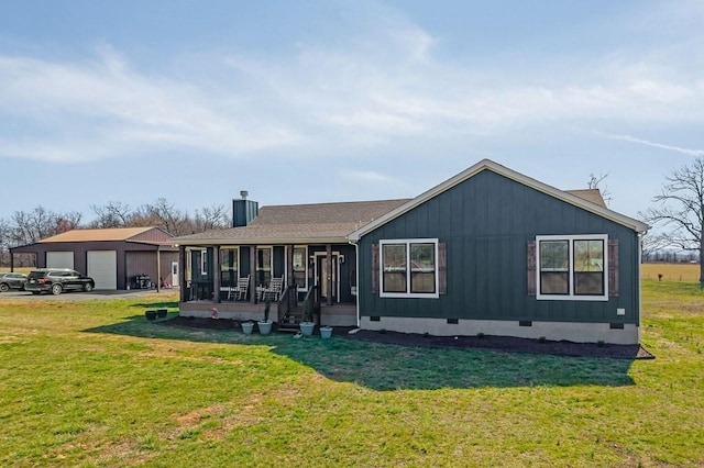 back of house with crawl space, an outbuilding, a lawn, and a garage