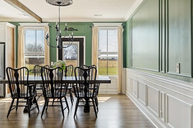 dining space featuring a decorative wall, a notable chandelier, a healthy amount of sunlight, and visible vents