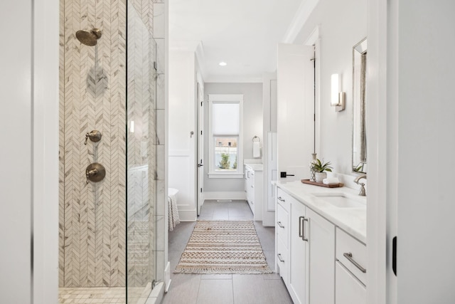 full bath with tile patterned flooring, a tile shower, vanity, and crown molding