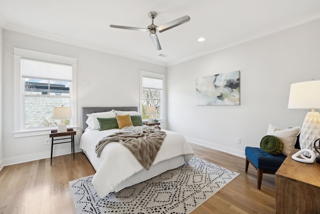 bedroom with light wood-type flooring, baseboards, ceiling fan, and crown molding