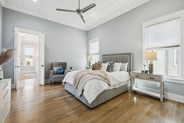 bedroom featuring ceiling fan, baseboards, wood finished floors, and ornamental molding