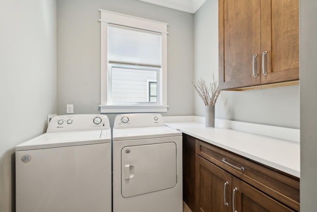 clothes washing area with washer and dryer and cabinet space