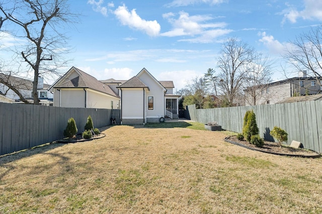 view of yard with a fenced backyard and a sunroom