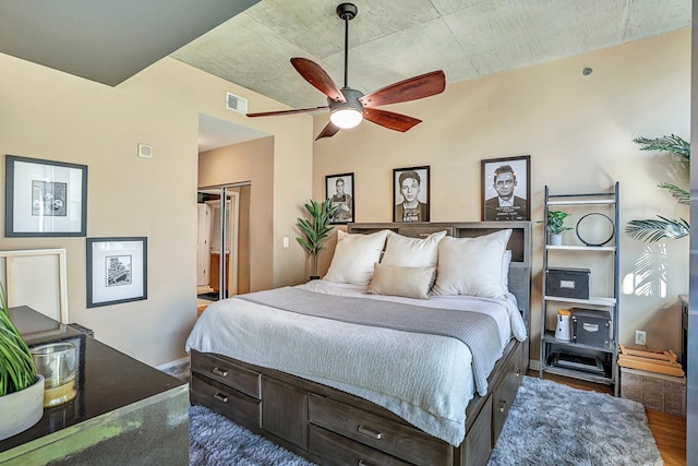 bedroom with a closet, visible vents, a ceiling fan, and wood finished floors