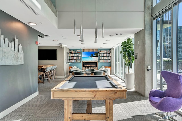 rec room with baseboards, carpet, a glass covered fireplace, and billiards